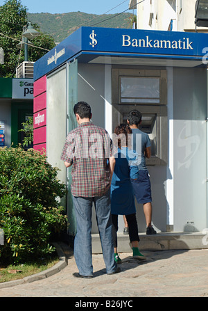 I clienti in attesa in linea per utilizzare il punto cassa della macchina e prelevare denaro in Marmaris MUGLA TURCHIA Foto Stock