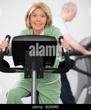 Senior di equitazione donna sulla macchina ginnica Foto Stock