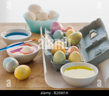 Uova decorate accanto a bocce di colorante Foto Stock