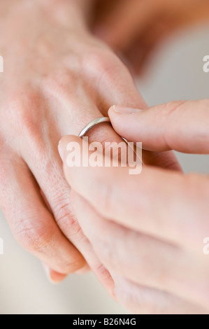 Uomo di mettere l'anello nuziale sulla donna del dito Foto Stock