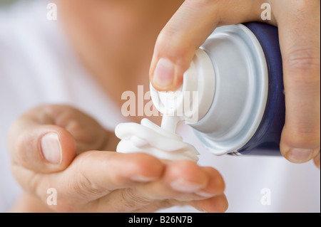 Uomo di rasatura con erogatore di crema in mano Foto Stock