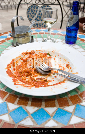 Avanzi di pasta sulla piastra con cucchiaio e forchetta Foto Stock