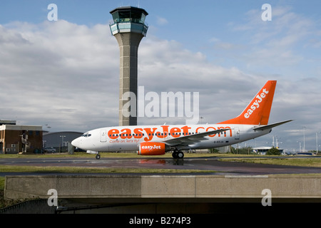 Un Boeing B737 series 700 del Regno Unito s bilancio EasyJet airline taxy s oltre la torre di ATC all'Aeroporto di Luton Foto Stock