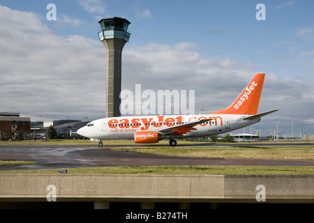 Un Boeing B737 series 700 del Regno Unito s bilancio EasyJet airline taxy s oltre la torre di ATC all'Aeroporto di Luton Foto Stock