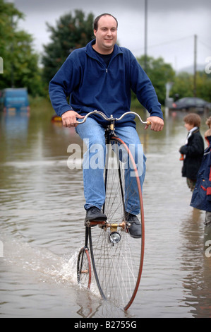 TEWKESBURY RESIDENT GRAHAM WEATHERLY cavalca il suo Penny Farthing attraverso l'acqua durante le inondazioni nel Gloucestershire Luglio 2007 U Foto Stock