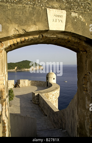 Dubrovnik Old Town 1834 muro di pietra archway torretta di framing e isola di Lokrum in Adriatico in background Foto Stock