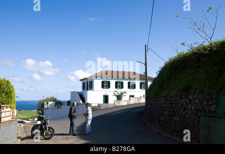 Due amici parlare in strada uno di loro possiede uno stile Americano a basso rider motociclo sull'isola di Faial Foto Stock