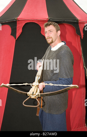 Reenactor del 11th° secolo all'esterno della tenda rossa, con balestra a balestra in balestra in balestra all'evento della Scottish Historical Sallire Society, Fort George, Ardersier, Scozia. Foto Stock