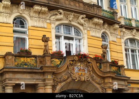 La facciata di un edificio in stile barocco, con composizioni floreali, statue e decorazioni di regal si trova nel cuore di Praga. Foto Stock