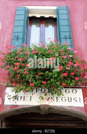 Romantica finestra ritagliata sulle tipiche case dipinte di rivestimento per le strade e canali del popolare isola veneziana di Burano Foto Stock