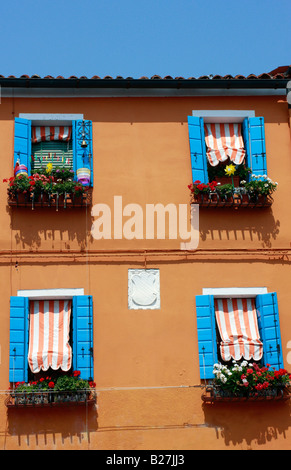 Tipico vividamente colorate case dipinte lungo le strade e canali del popolare isola veneziana di Burano Foto Stock