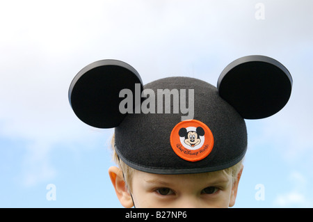 Un giovane ragazzo che indossa Mickey Mouse orecchie Foto Stock