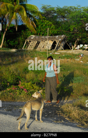 Donna con cane in un area povera vicino a Neiba villaggio sulla costa nord del lago Enriquillo, Repubblica Dominicana Foto Stock