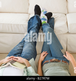 Giovani clienti di sesso femminile a piedi nudi la scelta di divano in  negozio mobili con cuscino Foto stock - Alamy