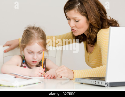 Madre aiutare mia figlia con i compiti Foto Stock