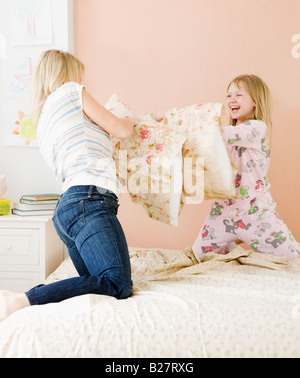 Madre e figlia avente pillow fight Foto Stock