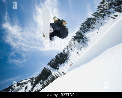 Uomo su snowboard in aria Foto Stock