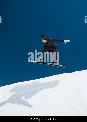 Uomo su snowboard in aria Foto Stock