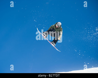 Uomo su snowboard in aria Foto Stock