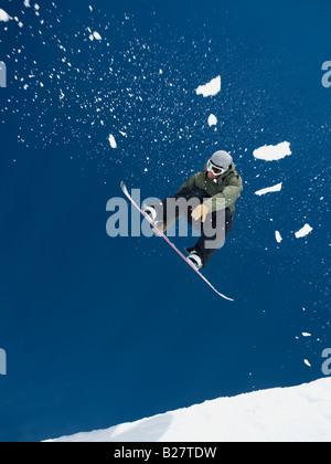 Uomo su snowboard in aria Foto Stock