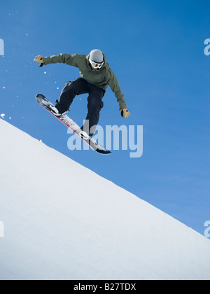 Uomo su snowboard in aria Foto Stock