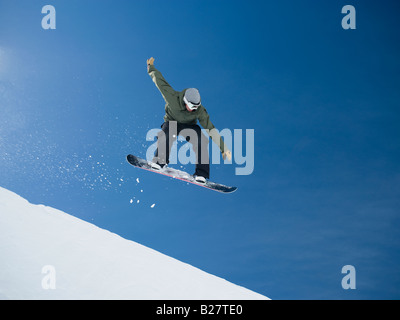 Uomo su snowboard in aria Foto Stock