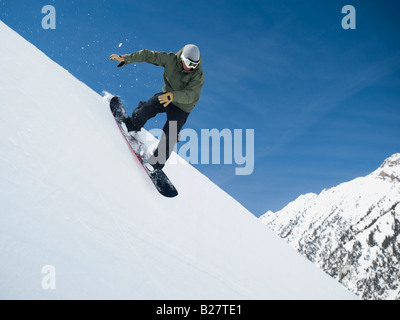 Uomo su snowboard in aria Foto Stock