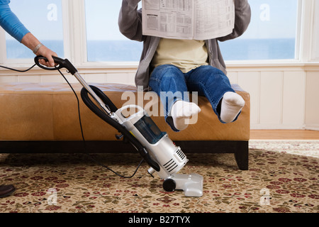 Aspirare la donna uomo sotto i piedi Foto Stock