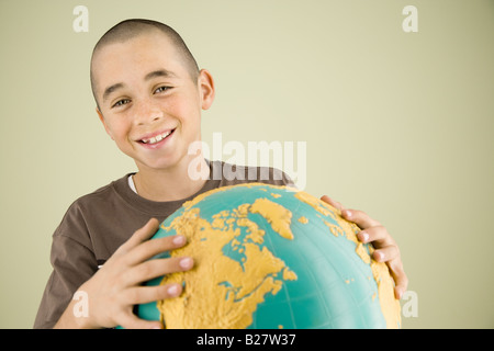 Ragazzo holding globe Foto Stock