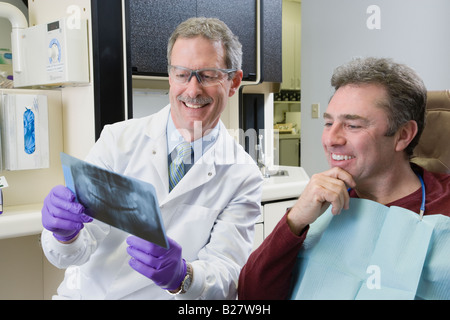 Maschio di dentista e paziente guardando a raggi x Foto Stock