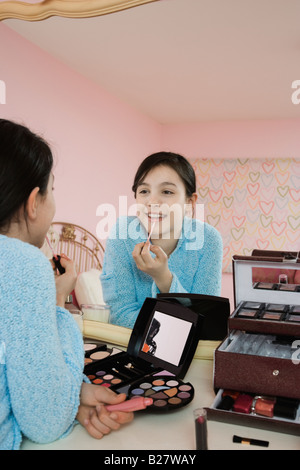 Ragazza applicando lip gloss Foto Stock