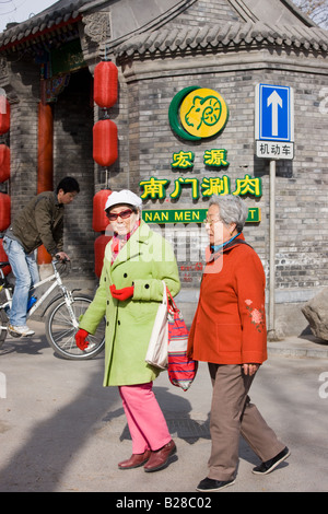Le donne anziane a piedi lungo il marciapiede in area di Hutong di Pechino CINA Foto Stock