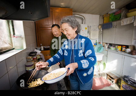 Il signor e la signora Wu la cottura dei fagioli nella loro cucina di casa nella zona di Hutong di Pechino CINA Foto Stock