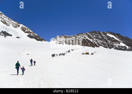 Gli escursionisti a piedi sulla parte superiore del Jungfraujoch nelle Alpi, Svizzera Foto Stock