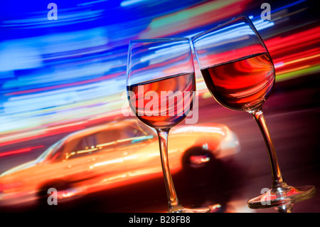 RETRO TIMES SQUARE due bicchieri da vino si appoggiano insieme al taxi giallo sfocato e alle spalle striature di luci al neon. Times Square, New York, Stati Uniti Foto Stock
