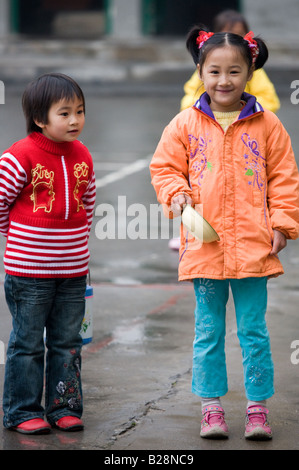 Le giovani ragazze nel parco giochi di una scuola primaria in Fuli la Cina ha una politica di bambino per limitare la popolazione Foto Stock