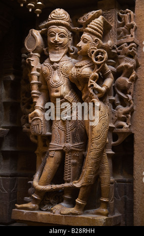 Una mano di arenaria scolpite re e la sua consorte in CHANDRAPRABHU tempio Jain all'interno di JAISALMER FORT RAJASTHAN IN INDIA Foto Stock