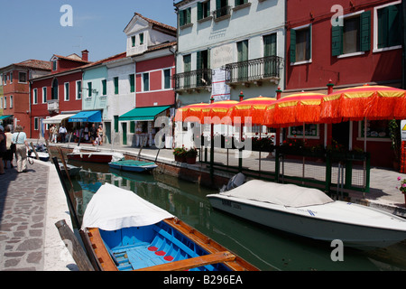 Ombrelli rosso lungo un canale di Burano,Laguna Veneziana.Italia Foto Stock