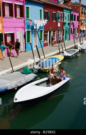 Tipico vividamente colorate case dipinte lungo le strade e canali del popolare isola veneziana di Burano Foto Stock