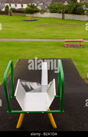 Visualizza in basso una diapositiva per bambini con vuoto rotonda e sedile unico in un parco giochi a Kikcudbright Scotland Regno Unito Regno Unito Foto Stock