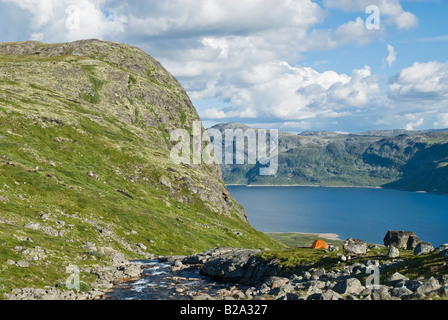 Orange singola persona tenda nelle montagne del parco nazionale di Jotunheimen con lago Bygdin in background, Norvegia Foto Stock