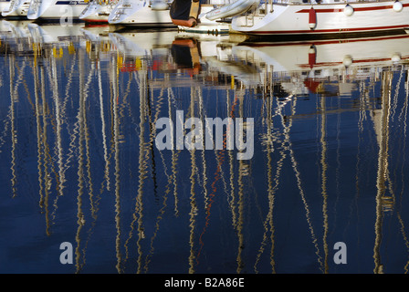 Linea di yacht a vela a montanti riflessa nell'acqua Foto Stock