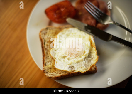 Pomodoro pancetta e uova fritte su pane tostato Foto Stock