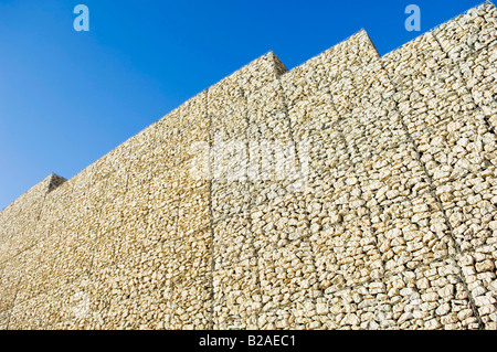 Parete di sicurezza fatta di una pila di scatole di presa di pietre Foto Stock