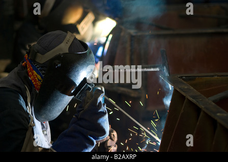 Due saldatrici a lavorare insieme su una costruzione in acciaio a un workshop di fabbrica Foto Stock