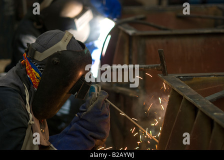 Due saldatrici a lavorare insieme su una costruzione in acciaio a un workshop di fabbrica Foto Stock