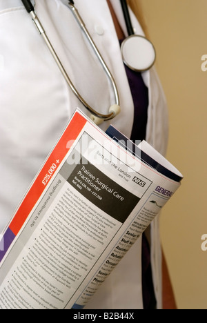 Annuncio di lavoro pubblicazione nella tasca uniforme di un membro della professione medica Foto Stock