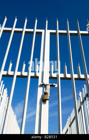 Moderno dentato per recinzione e cancello chiuso con un lucchetto Foto Stock