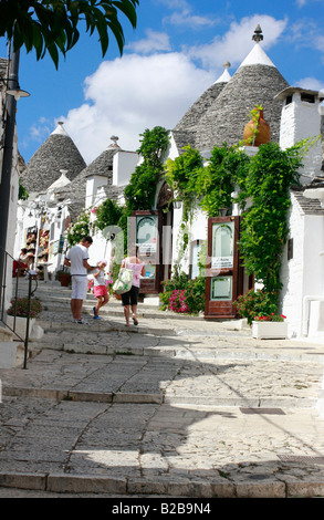 Il turista a godere di una suggestiva strada la zona unica di Trulli di Alberobello ,Bari, Puglia, che è un patrimonio mondiale dell' UNESCO Foto Stock