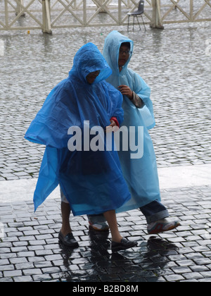 Giovane indossa impermeabile mantelli in Rain Foto Stock